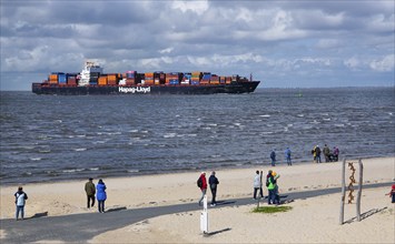 Beach promenade with container ship in the district of Döse, North Sea spa town of Cuxhaven, North