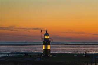 Black and white lighthouse, called 'Kleiner Preuße', stands on the coast in front of an