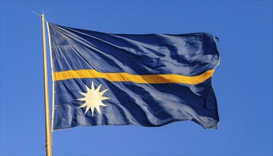 The flag of Nauru, an island nation in the Pacific Ocean, flutters in the wind, isolated against a