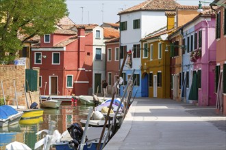 Colourful houses on a canal with boats, Mediterranean flair on a sunny day, Burano, Venice, Italy,