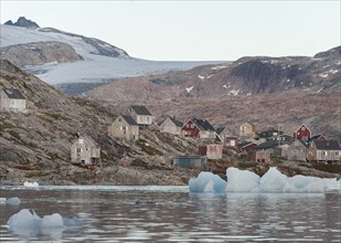 Icebergs in front of wooden houses in the Inuit settlement of Tiniteqilaaq, Sermilik Fjord, East