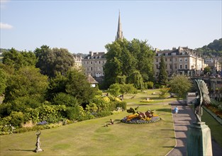 Parade Gardens public park in city centre of Bath, Somerset, England with church spire in