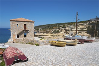 Small harbour with fishing boats and stone house on a rocky coast, Mezapos, Mani, Peloponnese,