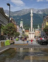 Maria-Theresien-Straße with Annasäule, old town of Innsbruck, behind the mountains of the Innsbruck