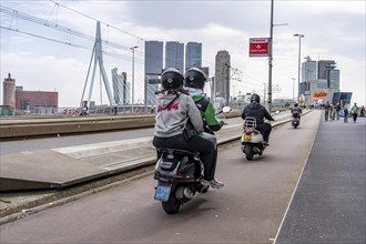 Scooter, cyclist on the cycle path of the Erasmus Bridge over the Nieuwe Maas, skyline of