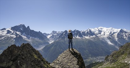 Mountaineer standing on a rock, mountain landscape with mountain peaks Grandes Jorasses, Aiguille