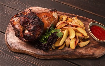 Pork knuckle, in soy-honey sauce, with fried potatoes, on a wooden chopping board, homemade, no