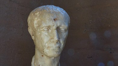 Marble bust of Julius Caesar, marble bust of a Roman emperor or nobleman, against a dark