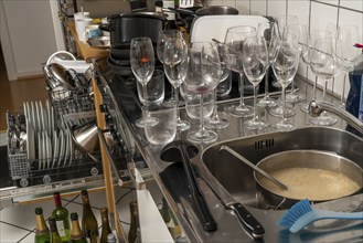 Kitchen after a big dinner, cooking party, dishwasher, full, with cleaned dishes, dirty glasses,