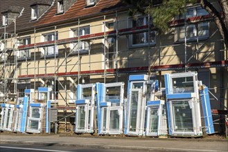 Energy-efficient refurbishment of residential buildings, older apartment block is scaffolded, gets