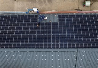 Installation of solar modules on the roof of a barn on a farm, over 210 photovoltaic modules are