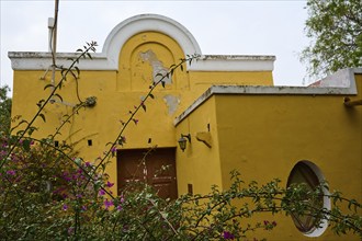 Former residence of Lawrence Durell, A yellow building in need of renovation with curved windows,