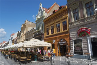 Cosy street café in a lively old town with historic architecture on a sunny day, town houses, old