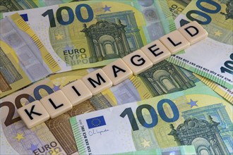 Symbolic image of climate money: Letters on euro notes display the word climate money