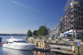 Modern harbour with yachts and buildings on a sunny day under a blue sky, capital city, Aker