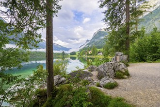 Hintersee with rocks and trees in the foreground, cloudy sky, Ramsau, Berchtesgaden National Park,