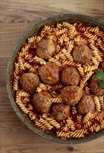 Minced meat meatballs, in tomato sauce, with fusilli pasta, in a cast-iron pan, homemade, no people