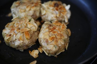 Swabian cuisine, meatballs wrapped in almonds, mixed minced meat, frying meatballs in fat, frying