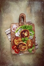 Fried chicken cutlets, minced chicken, with vegetables, on a cutting board, with vegetable salad,