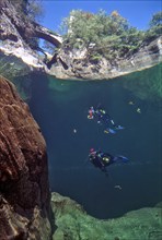 View from underwater through the water surface of the river Orrido di Sant' Anna on top foreground