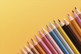 Colorful pencils on yellow background with copy space. KI generiert, generiert AI generated