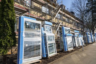 Energy-efficient refurbishment of residential buildings, older apartment block is scaffolded, gets