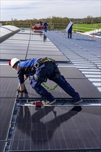 Installation of solar modules on the roof of a commercial enterprise, over 400 photovoltaic modules