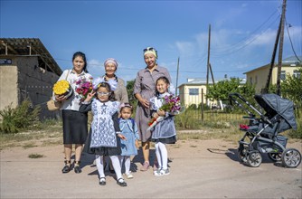 Family and schoolgirl with a bouquet of flowers on the first day of school, Issyk-Kul region,