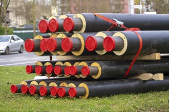 Pipe for district heating connections lying on a construction site on a stockpile, to be laid to