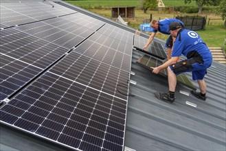 Installation of solar modules on the roof of a barn on a farm, over 240 photovoltaic modules are