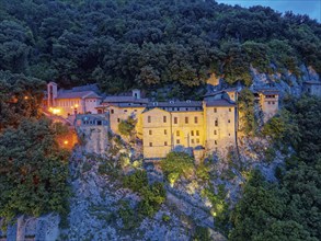 Illuminated at dusk is the Santuario di Greccio hermitage, also known as the Santuario Francescano