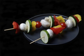 Colourful vegetable skewers on a plate, barbecue skewers