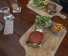 Veggie burger with fries and salad served on a wooden board, Bavaria, Germany, Europe