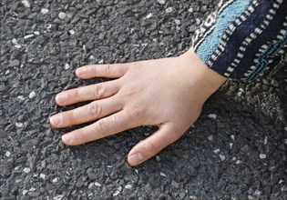 A Last Generation activist has her hand glued to a street, Berlin, 24 04 2023