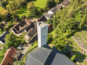 A church with a tower in a village surrounded by green nature and small houses, Gundringen, Nagold,