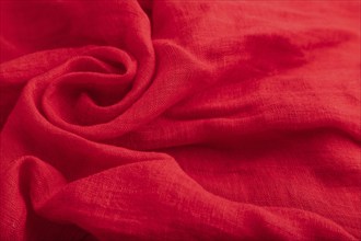 Fragment of red silk tissue. Side view, natural textile background and texture. wave concept,