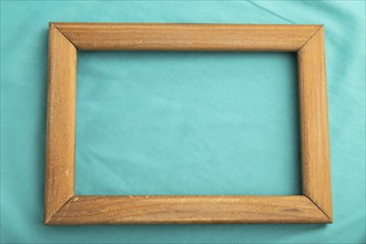 Wooden frame on smooth silk blue tissue. Top view, flat lay, natural textile background and texture