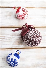 Christmas or New Year composition. Decorations, knitted balls, on a white wooden background. Top