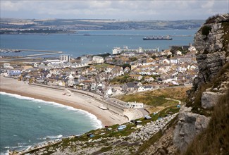 Chiswell village at the start of Chesil Beach with Weymouth harbour beyond, Isle of Portland,