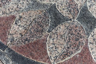 Granite leaf-like mosaic maroon-black element in the park