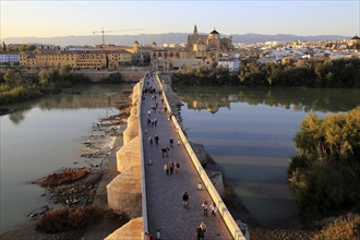 Roman bridge spanning river Rio Guadalquivir with Mezquita cathedral buildings, Cordoba, Spain,