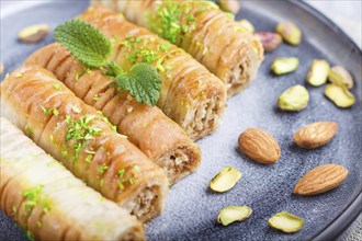 Baklava, traditional arabic sweets in gray ceramic plate on a gray concrete background. side view,