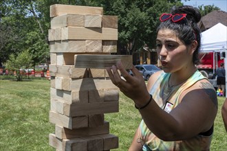 Detroit, Michigan, A woman plays jenga at the annual 'Summer Sizzler' picnic and party held by two