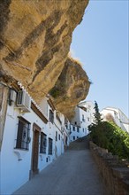 White houses in Setenil de las Bodegas under rocks, sunny sky, cave dwellings, Setenil de las