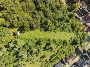 A cemetery in a green wooded area right next to a village, bird's eye view, Gundringen, Nagold,