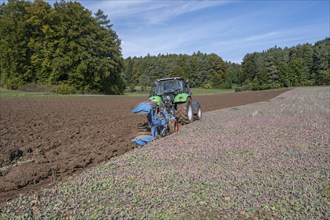 Farmer with tractor ploughing his field with a 5-turn rotary plough, Franconia, Bavaria, Germany,