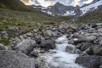 Mountain stream Furtschaglbach at sunrise, long exposure, rocky mountains behind, summit