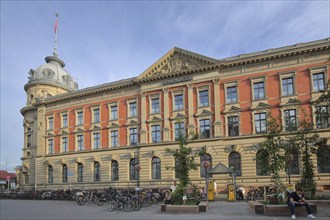 Historic building of the Sparkasse, former main post office, people, bicycles, car park, market