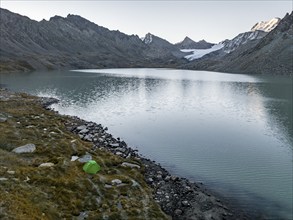 Wild camping, camping with tent in the mountains with glacier, mountain pass and mountain lake