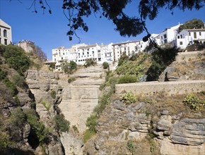 El Tajo canyon of the Rio Guadalevin river with white buildings perched on the cliff top, Ronda,